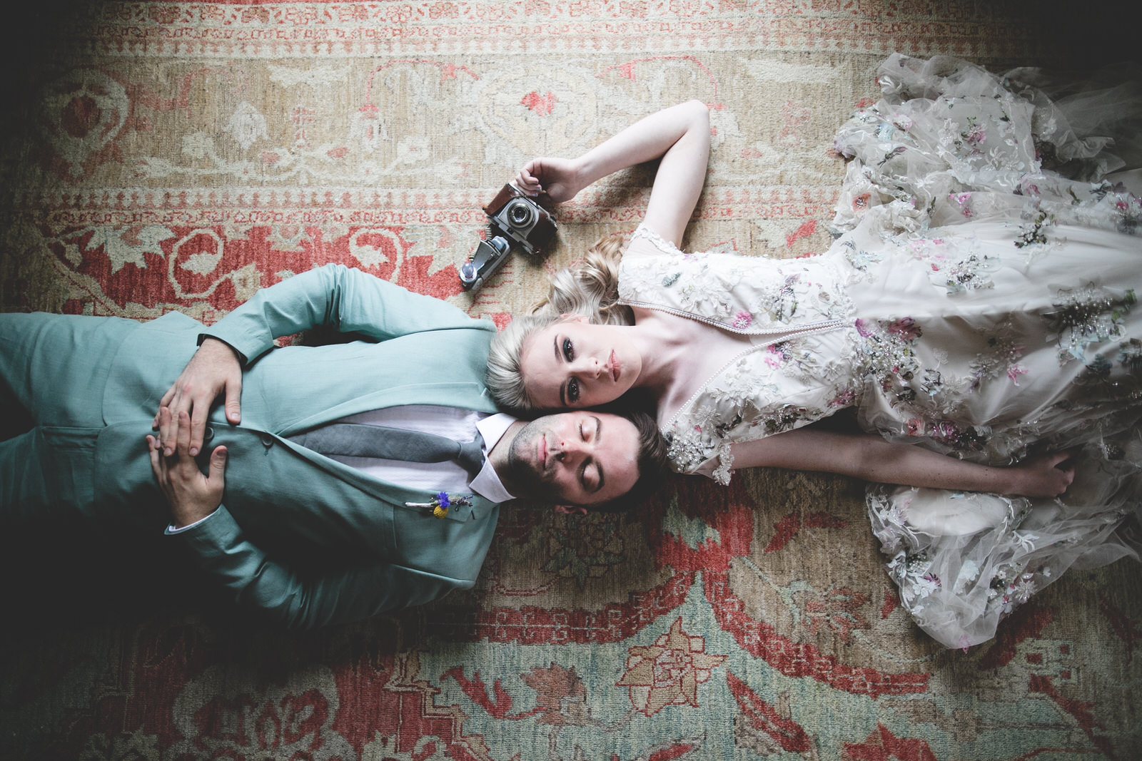 overhead shot of a bride & groom lying on the floor 