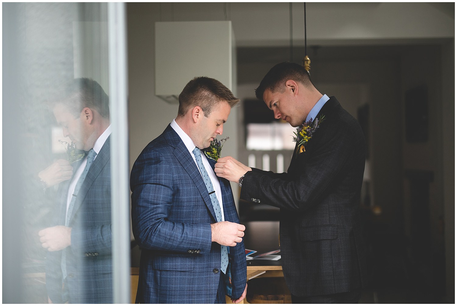 Grooms fixing each others boutonnieres 