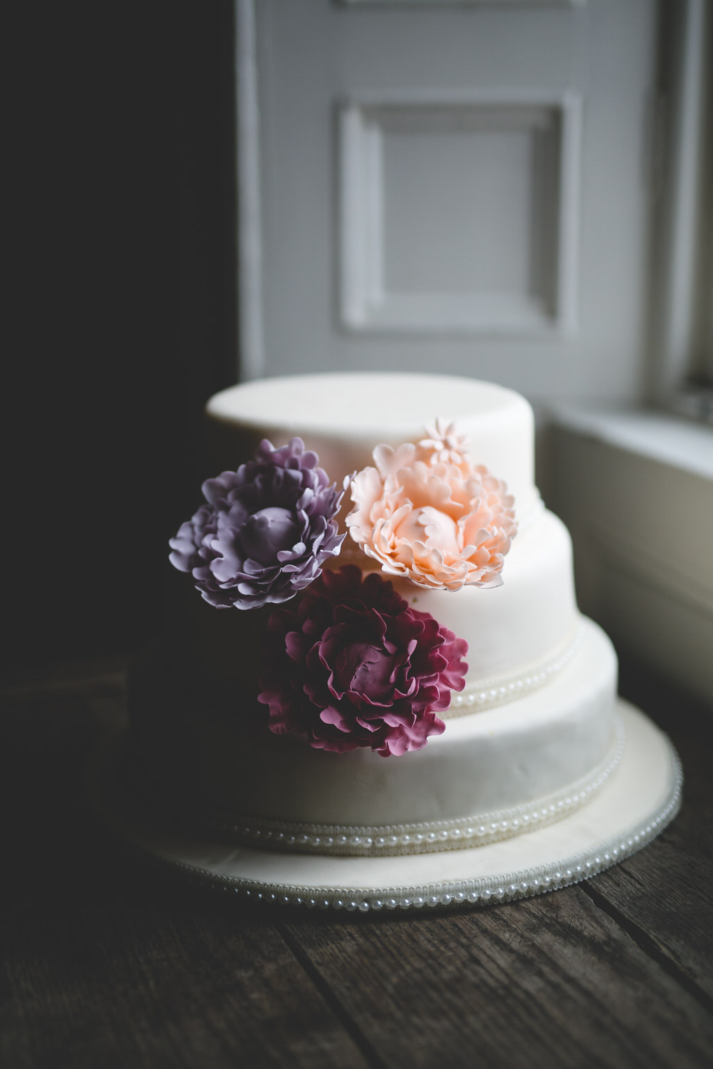 Simple, stylish & elegant wedding cake in white with iced flower decorations